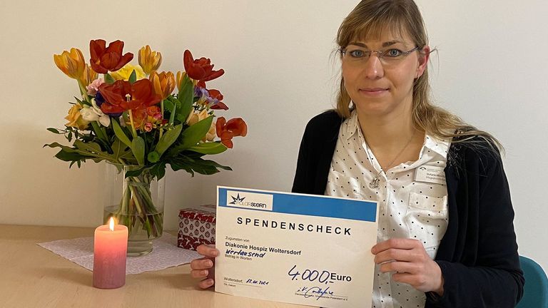 Diakonie Hospiz Woltersdorf - Pflegedienstleitung Stefanie Micklitza hält Spendenscheck von Förderverein Polarstern in der Hand